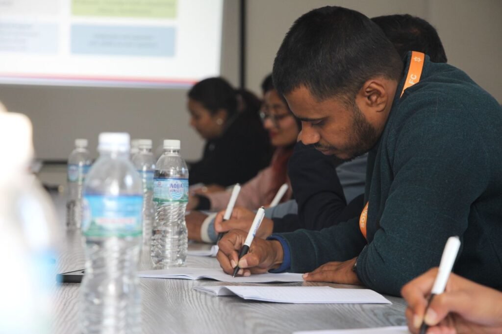 Focused students taking notes during a classroom seminar indoors.